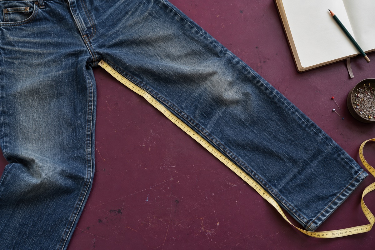 Jeans lagt fladt med et målebånd langs den indvendige bensøm.